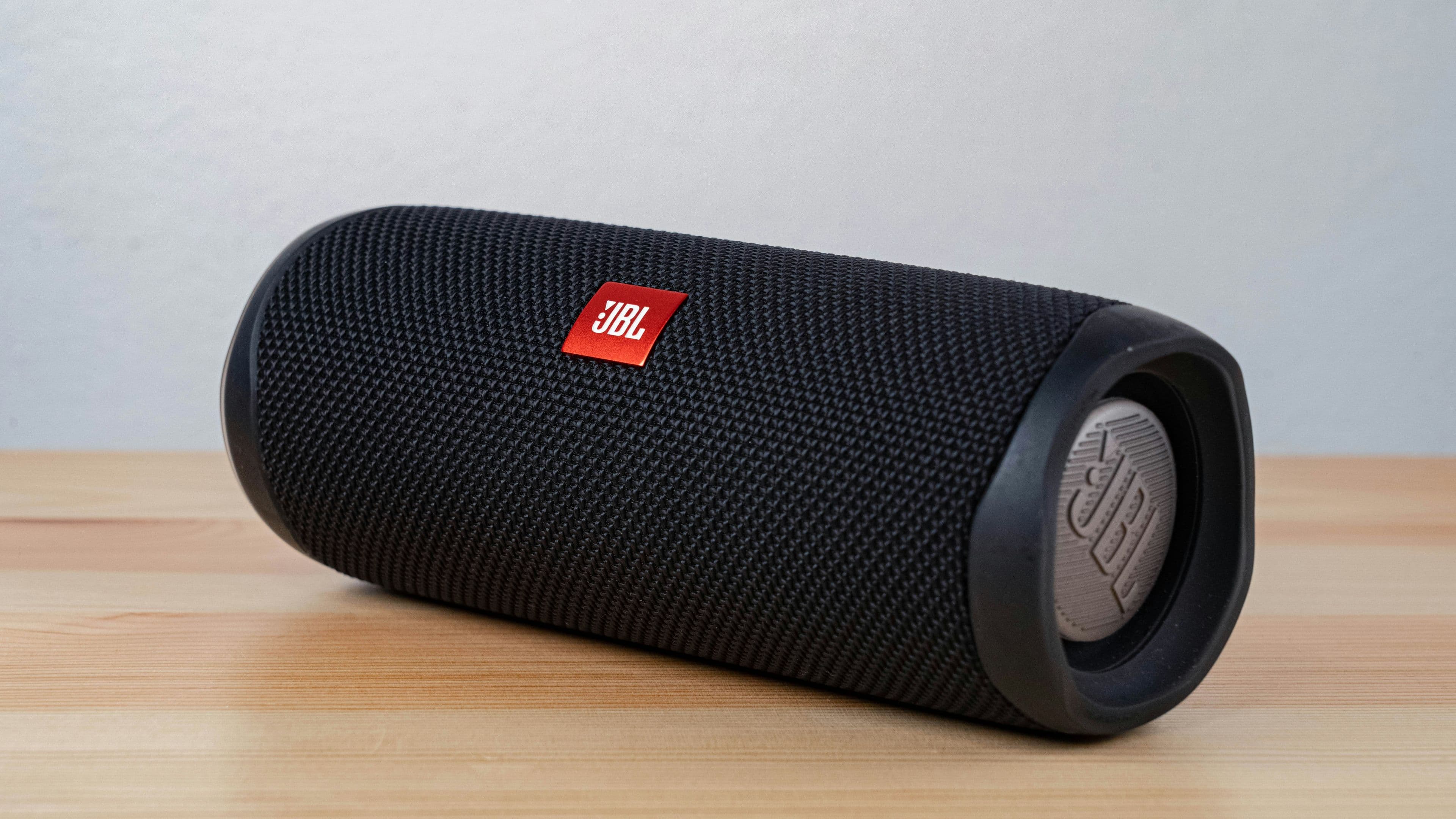 A compact Bluetooth speaker sitting outdoors on a picnic table