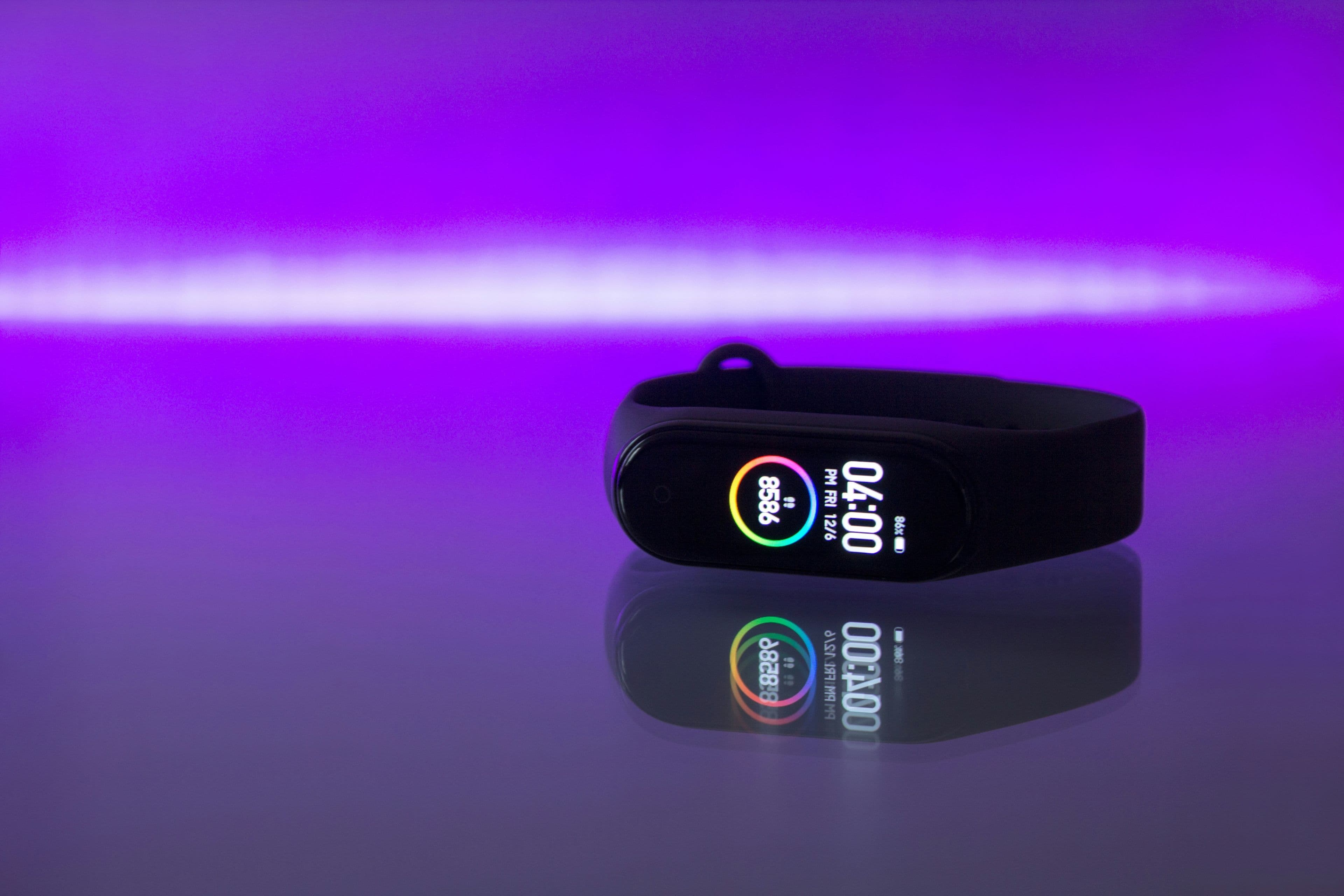 A slim fitness band on a wrist showing step count and heart rate